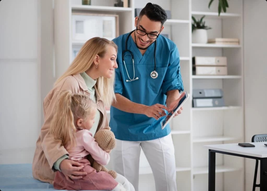Clinician showing a tablet to a mother and child during an ABA insurance consultation
