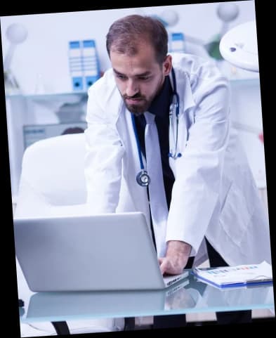 Doctor reviewing claims on a laptop