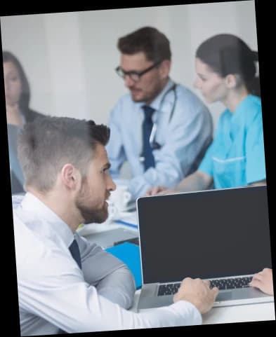 Coding team reviewing charts together around a laptop