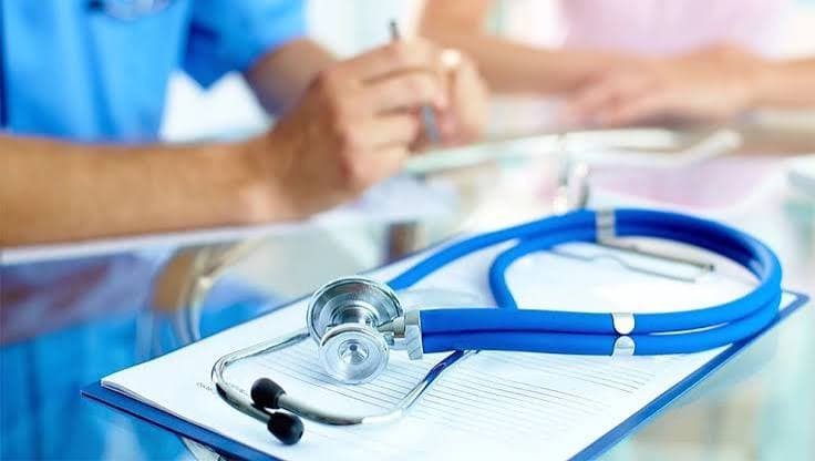 Provider signing a credentialing document with a stethoscope nearby