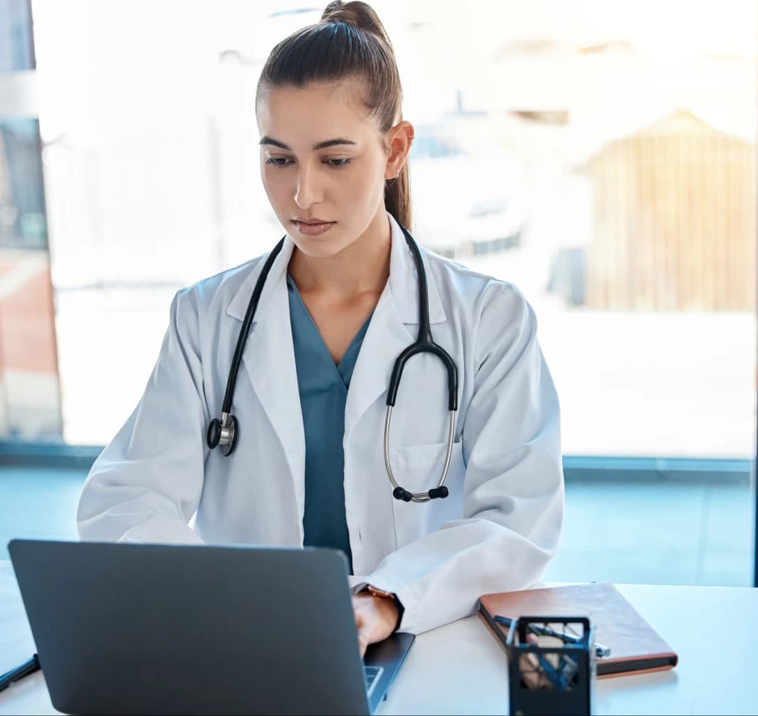 Physician reviewing billing software on a laptop