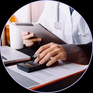 Clinician reviewing figures on a calculator and tablet