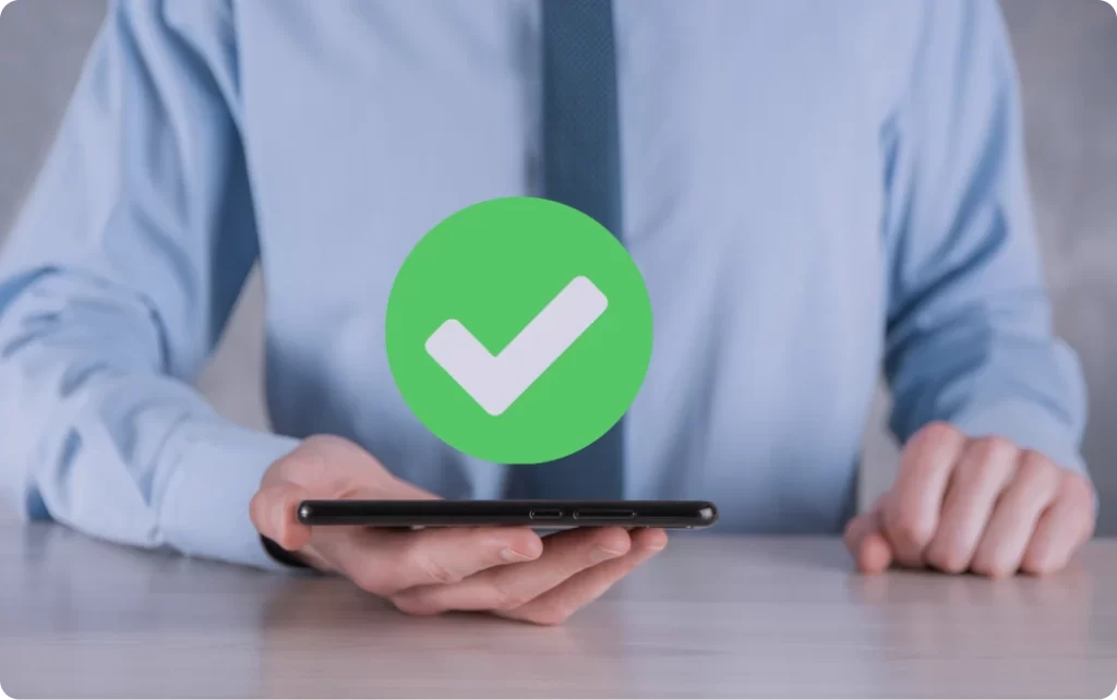 Person holding a phone with a green checkmark, representing an approved submission