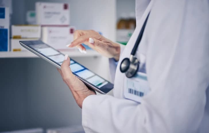 Doctor reviewing pharmacy records on a tablet